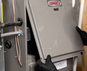 HVAC technician installing Lennox brand furnace
