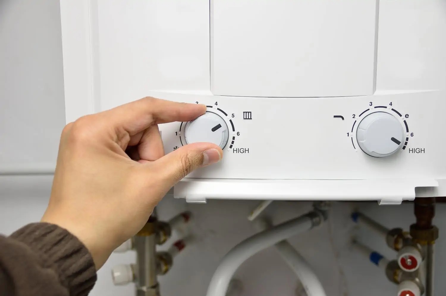 Person adjusting temperature setting on a tankless water heater