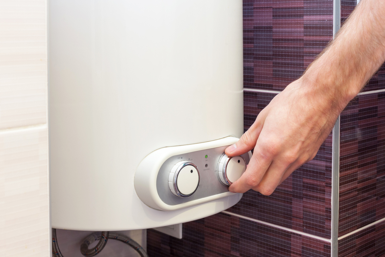 homeowner using tankless water heater dials to adjust settings