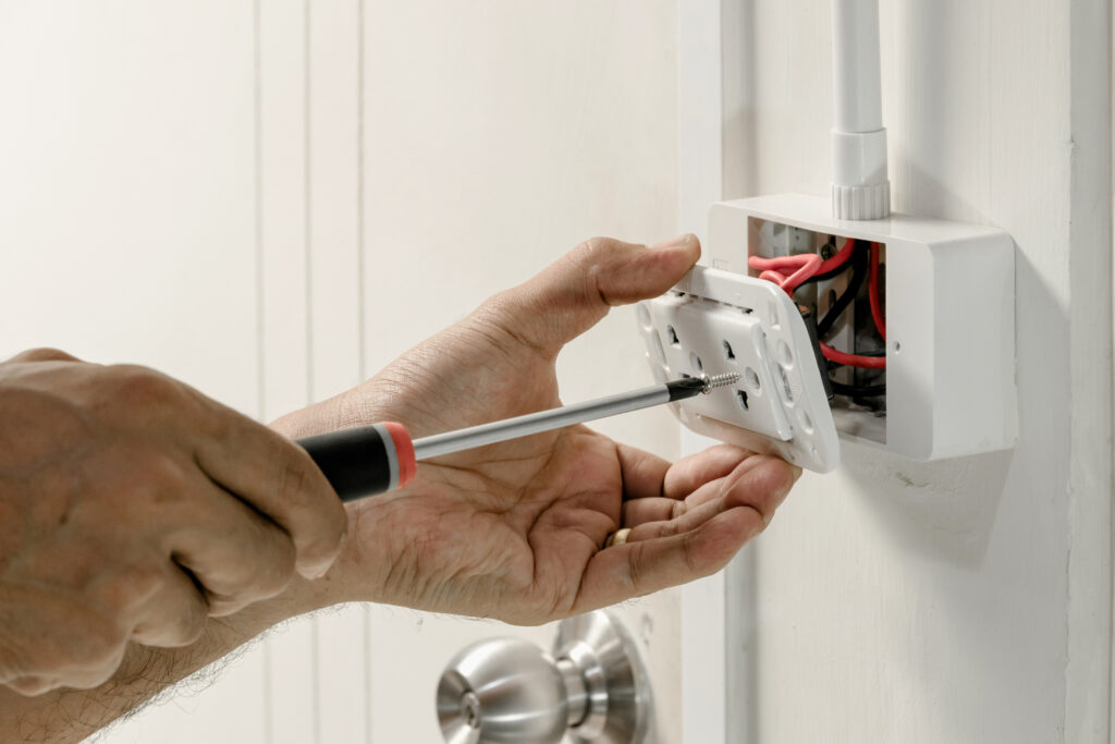 Electrician removing a residential power outlet for repair